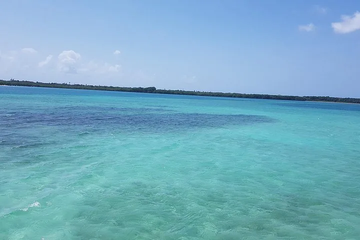 A view of the horizon over beautiful, clear turquoise water near a coastline.